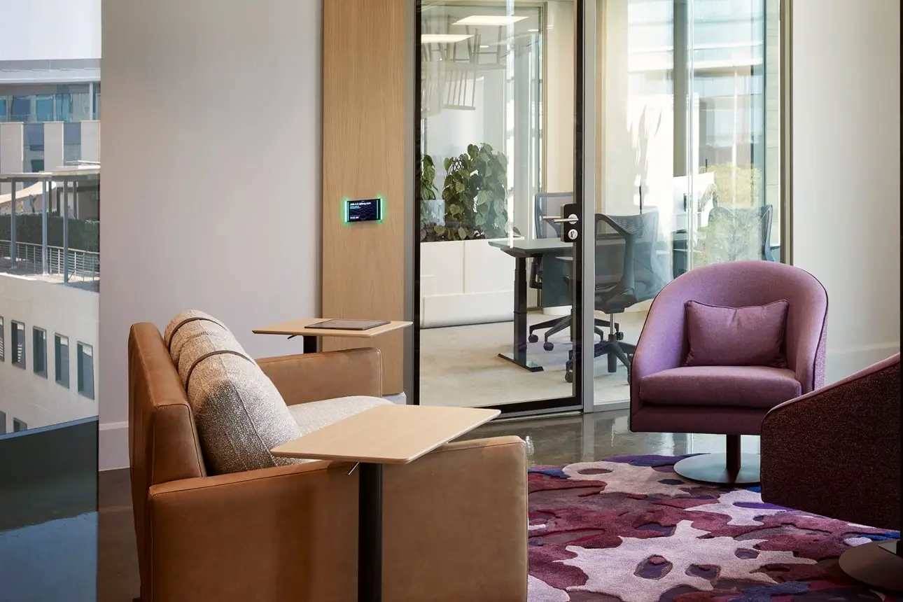 Informal meeting room with modern chairs, cushioned seating and colourful rug in BCG office