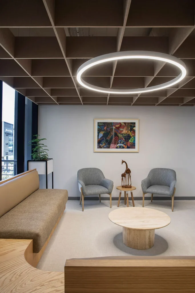 Seating area with circular pendant lighting and wall art in European Investment Bank office in Johannesburg