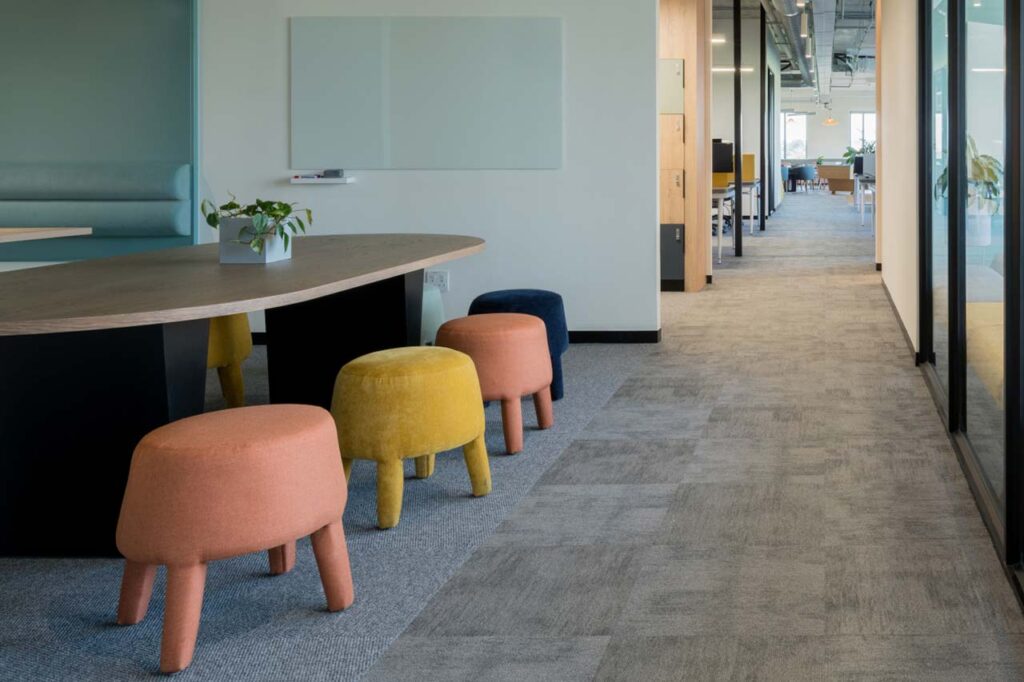 Seating area with colourful ottomans in Impact office in Cape Town