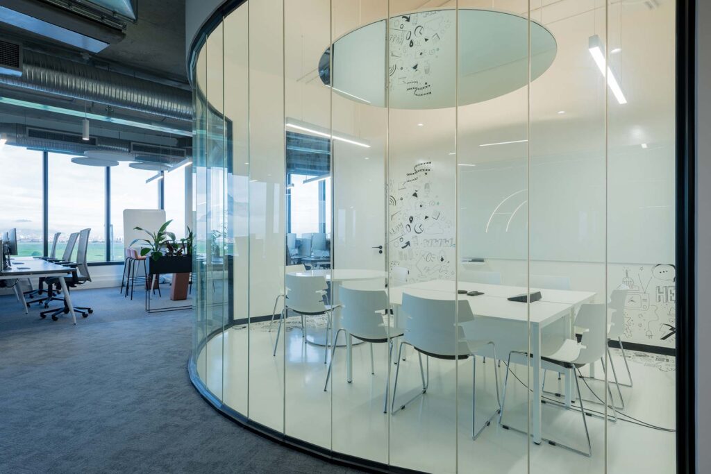 White chairs for private meeting room behind glass partition in contemporary workplace