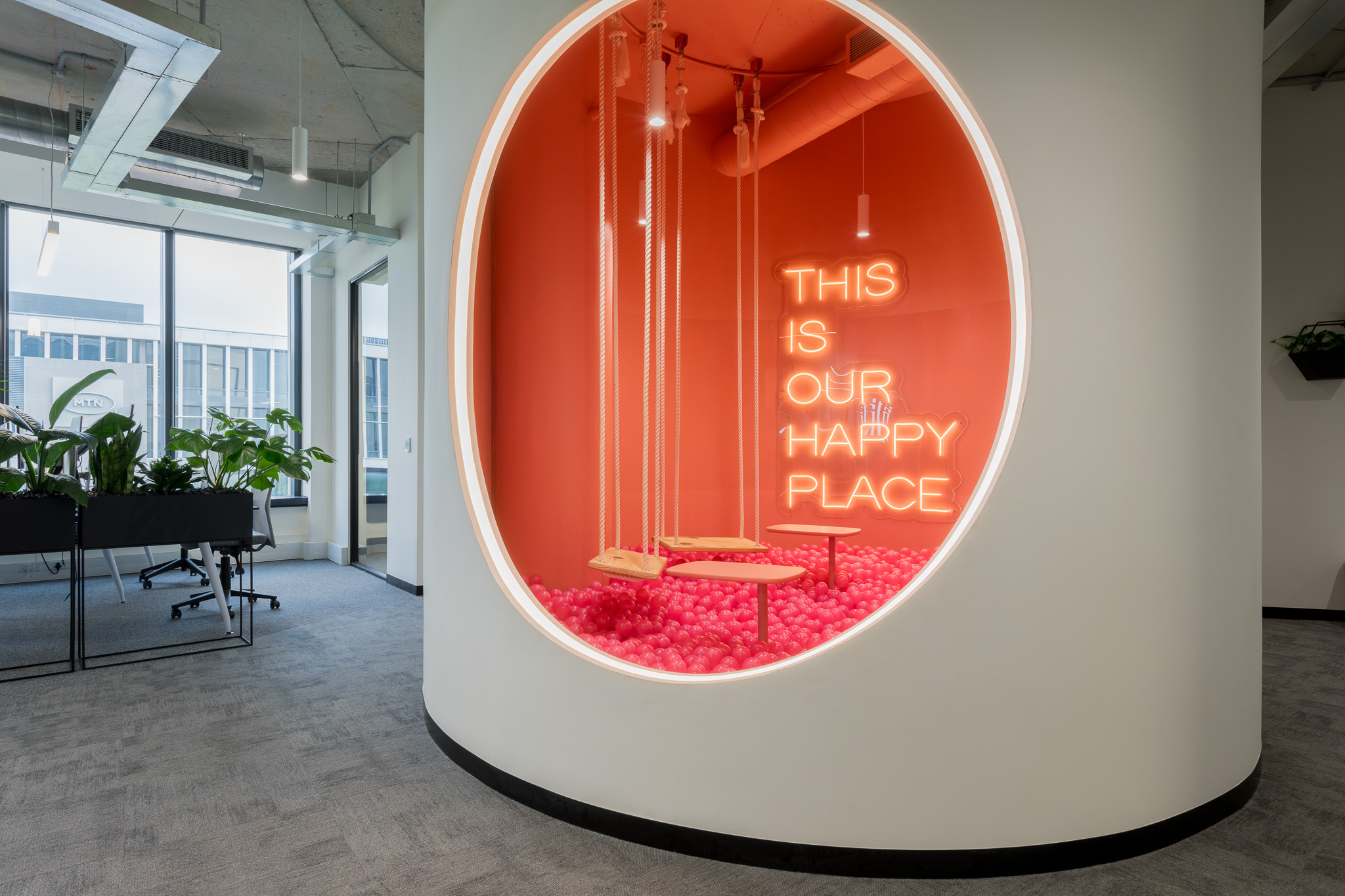 Feature installation with swing elements and neon signage in Impact office in Cape Town