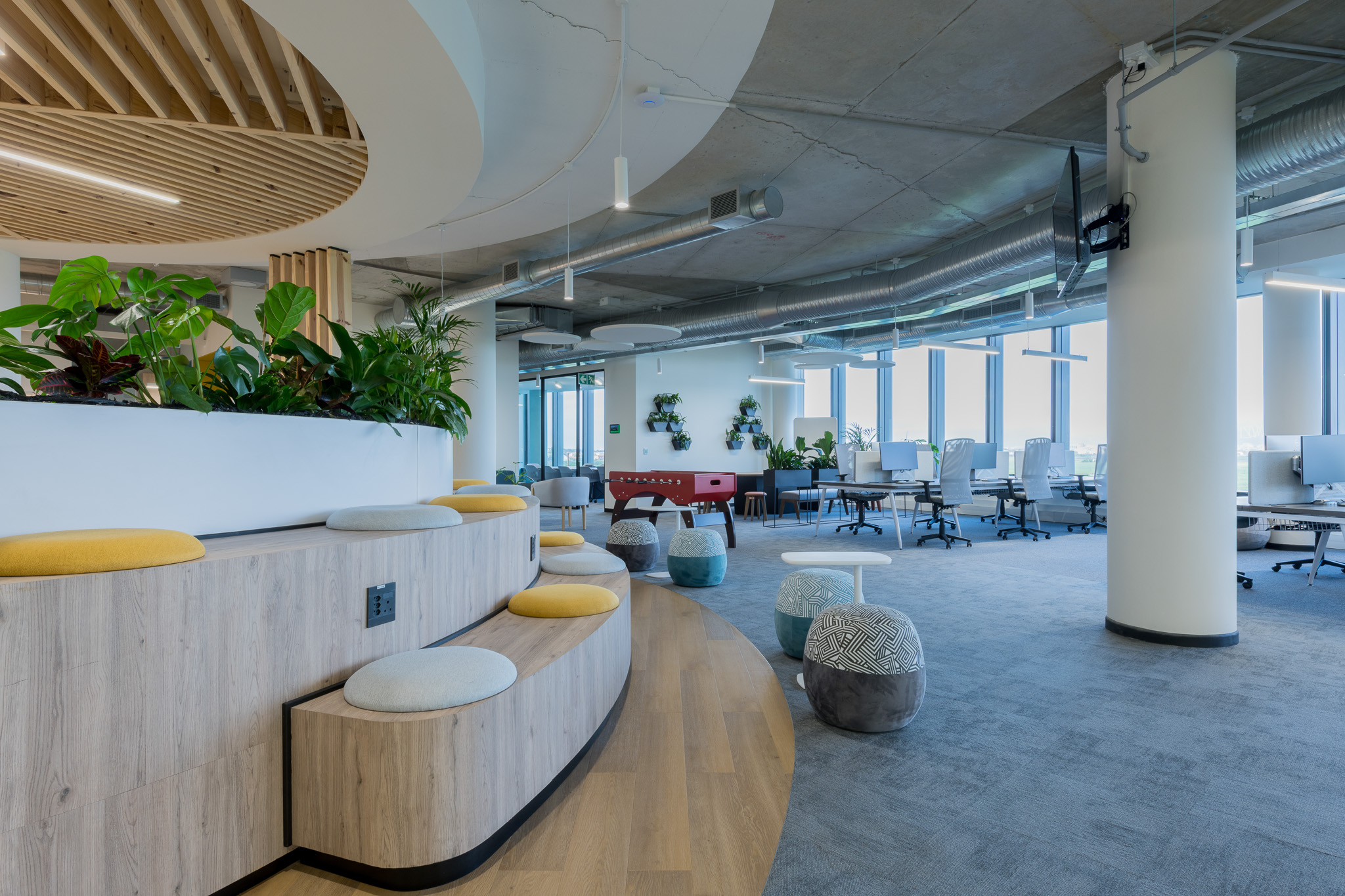 Amphitheatre seating area with benches and ottomans in Impact office in Cape Town