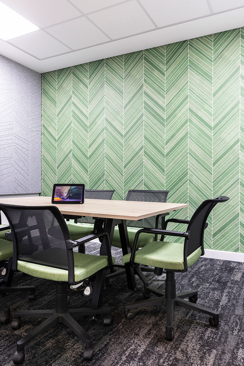 Meeting area with desks, ergonomic chairs and green wall in Pinsent Masons office in Rosebank