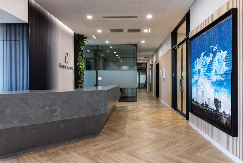 Reception area with artwork and marble reception desk in Pinsent Masons office in Rosebank