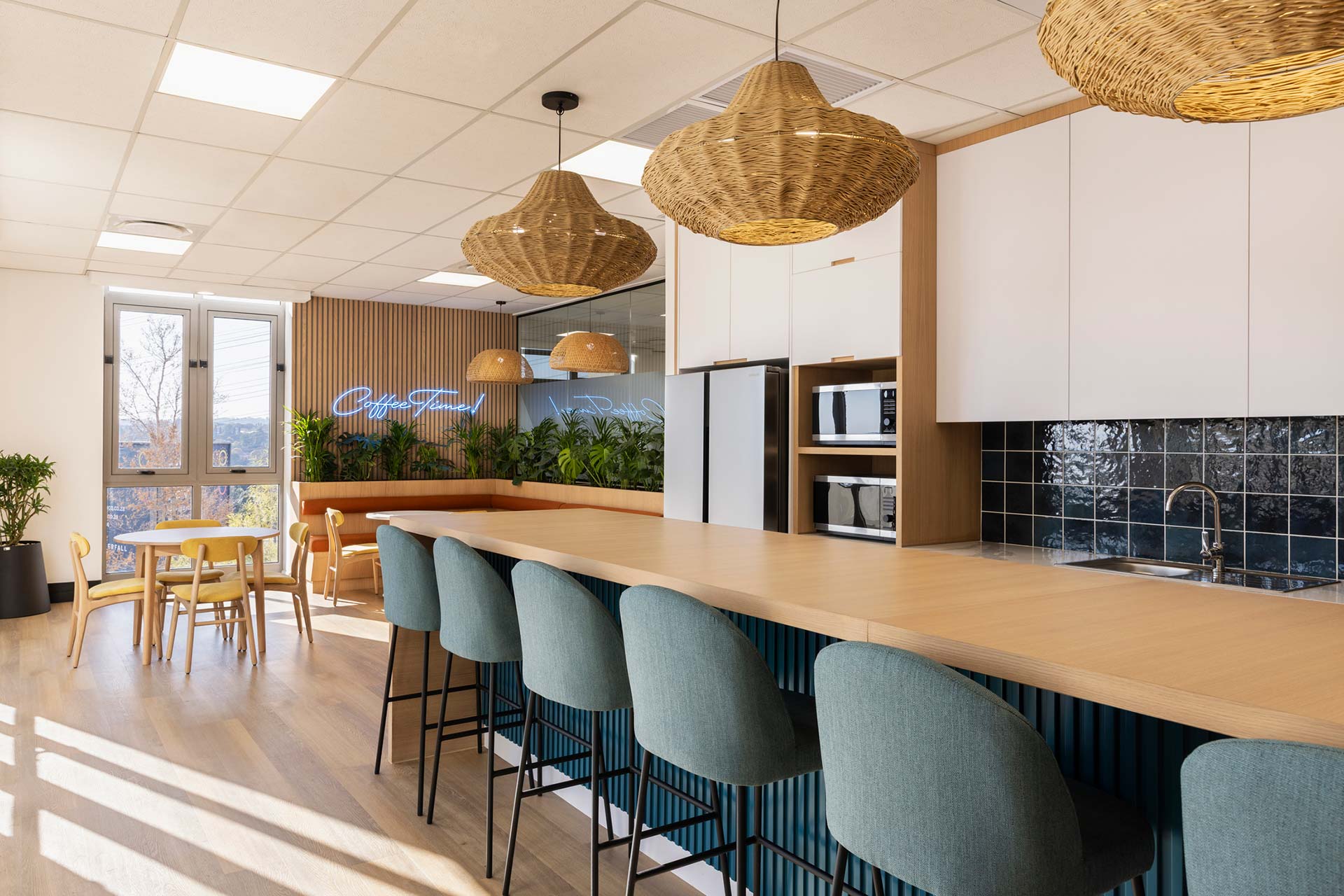 Canteen area with cushioned bar stools and kitchenette in Sandoz office in Johannesburg