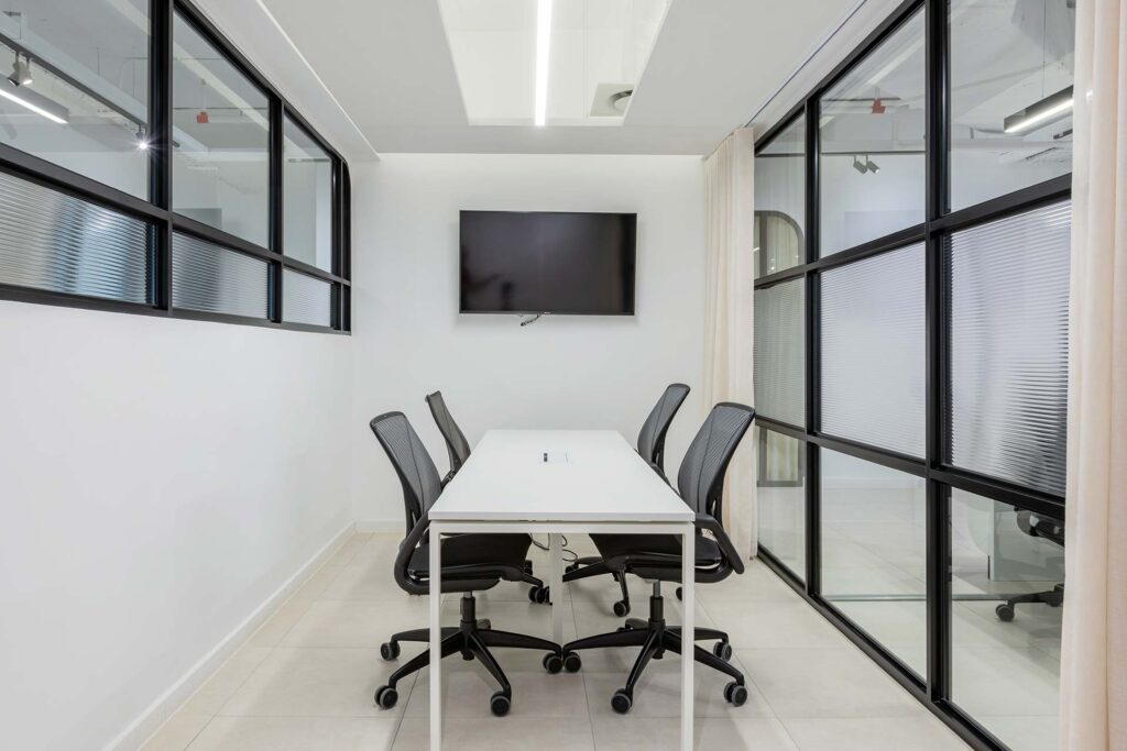 Corner meeting area with table, chairs and TV in Superbalist workspace in Cape Town