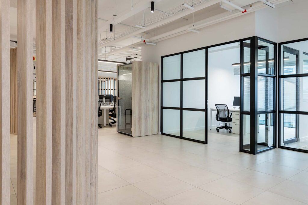 Private rooms with glass partitions and black-framed walls in Superbalist office in Cape Town