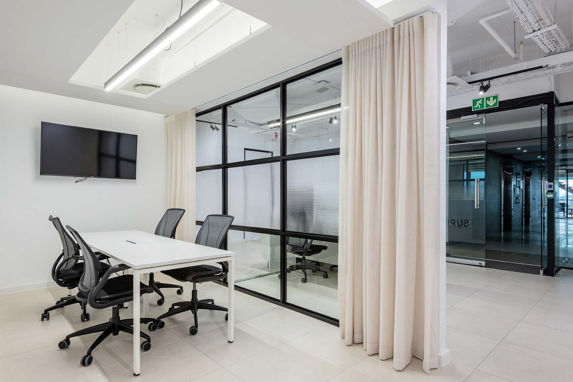 Work area with curtain for privacy and ergonomic seating in Superbalist workspace in Cape Town