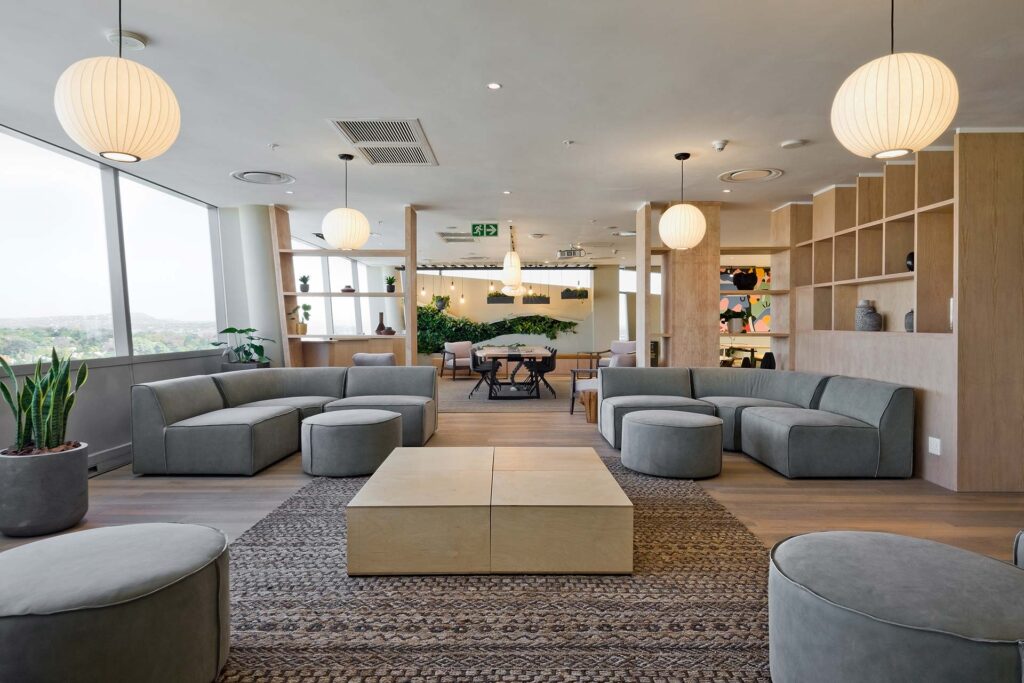 Design Colab furnished P&G South Africa's open-plan office with custom couches, seating, and wooden shelving.