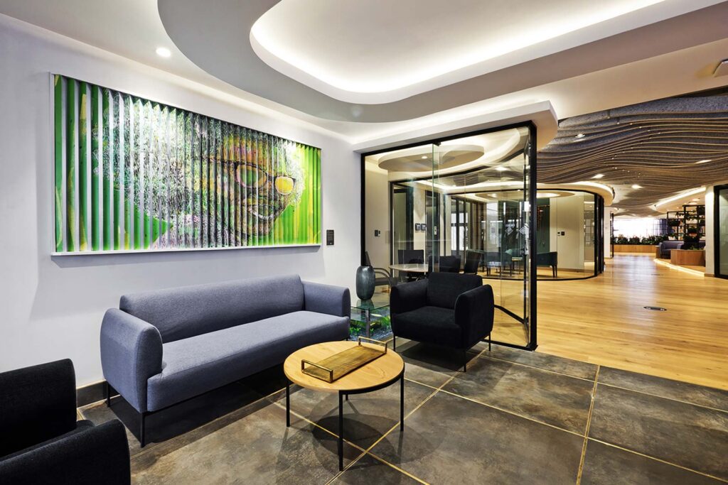 Liberty Sandton reception area with contemporary seating, tables upholstered in durable, high-performance fabrics supplied by Design Colab, and modern art displayed on the wall.