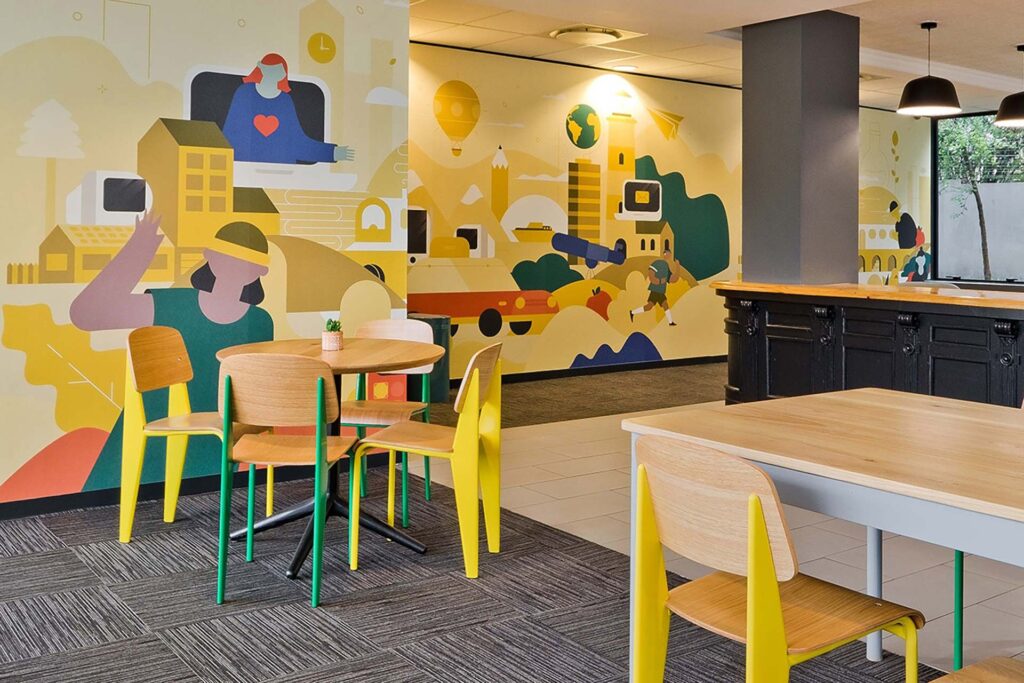 Valenture Johannesburg educational facility canteen with colourful wooden chairs and desks designed to complement the brand identity