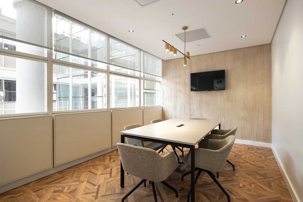 Letsema Rosebank's commercial office interiors feature a conference room with luxury chairs and a wooden meeting table.