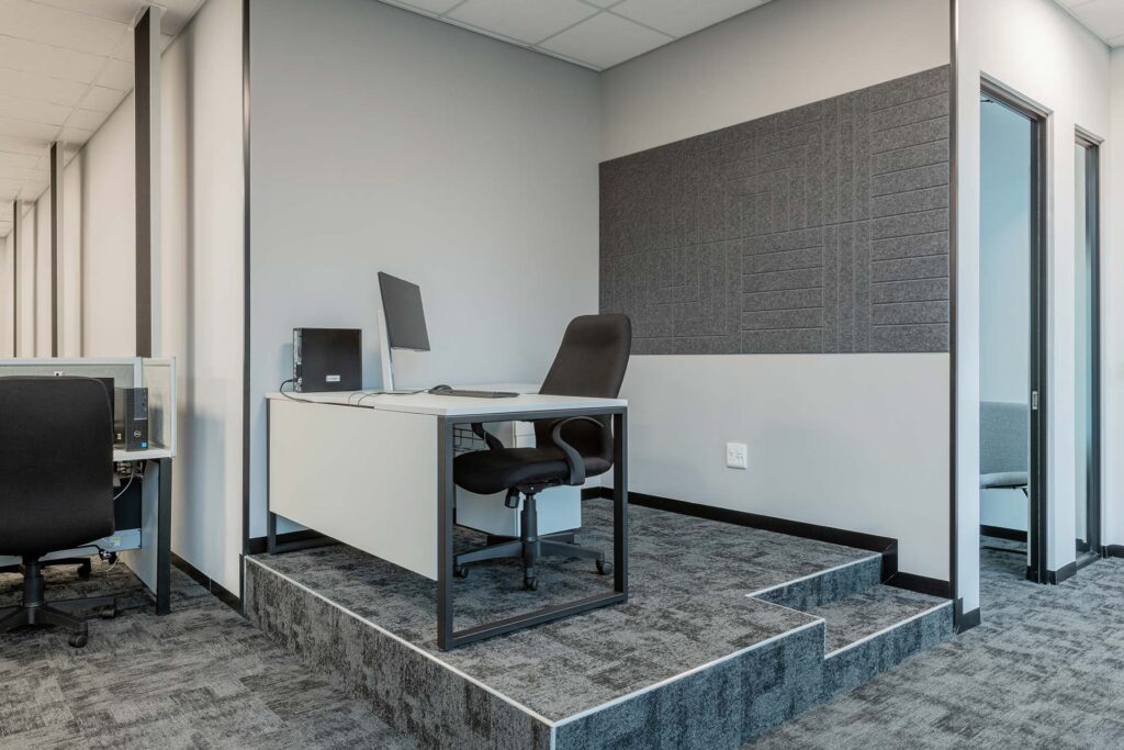 Call centre corner workstation with modern desk, ergonomic seating and acoustic wall panels, showcasing efficient workplace furniture solutions