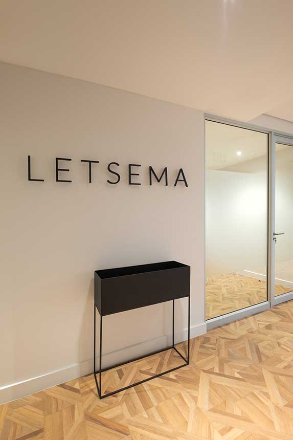 Letsema office entrance with signage and black planter box, featuring Furniture Solutions.