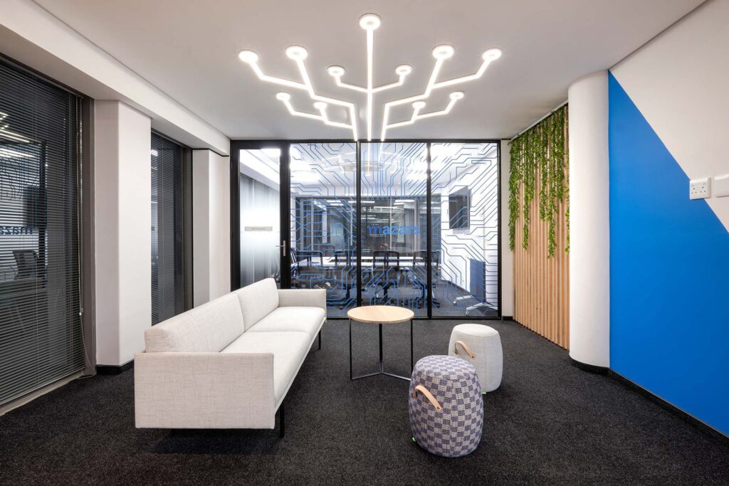 Mazars' high-tech commercial office features custom lighting and luxurious corporate couches and ottomans for reception areas, all procured by Design Colab SA.
