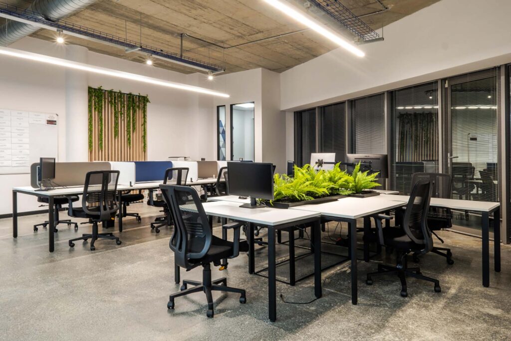 Mazars Johannesburg: Personalized desking solutions, including operators' chairs, planters, and shared-desk options for an open-plan green office.