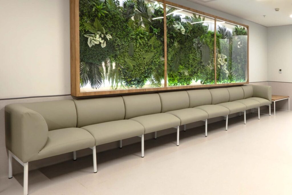 Nephrology reception area with seating, couch, and plant wall.
