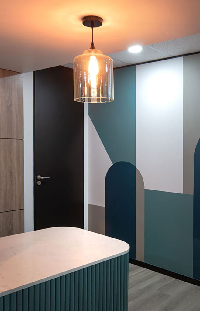 One Vision Pretoria: custom commercial lighting and desks in company brand colors.