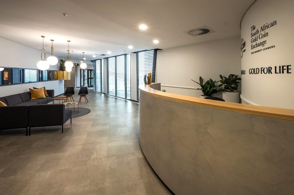 SA Gold Coin: reception area furniture, including couches, cushions, lighting, decor, and workspace furnishings.