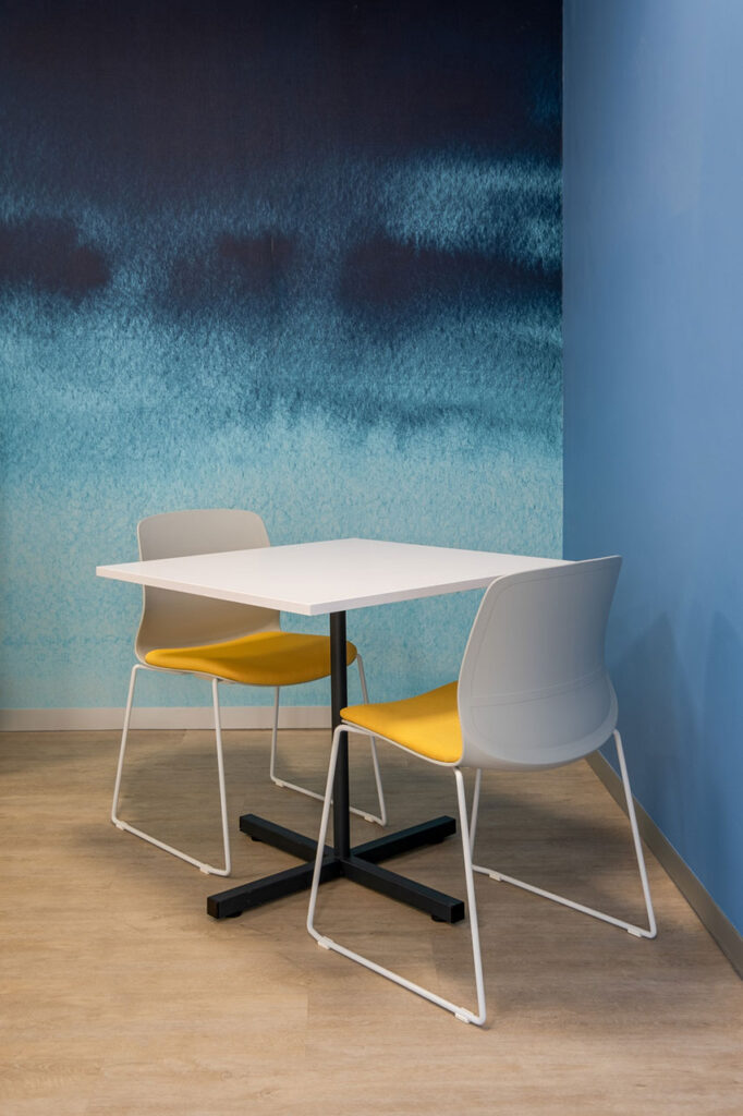 Sanlam Houghton canteen with modern tables and yellow padded seating, showcasing contemporary workplace furniture