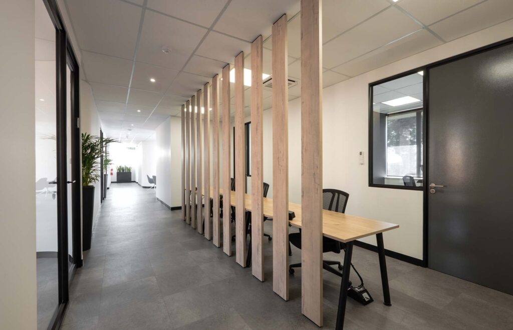 Snowsoft open-plan office with shared timber desks, ergonomic chairs and timber slatted partitioning, showcasing modern workspace planning and furniture solutions