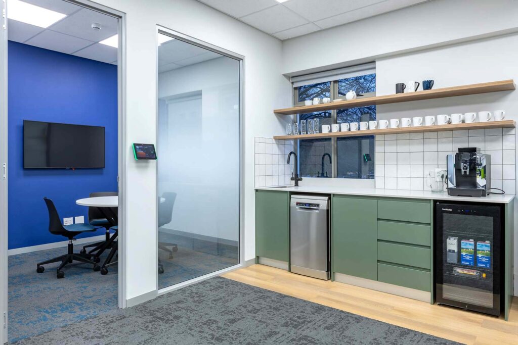 United Exports Paarl coffee station with modern cabinetry, round desk, task chairs and colourful office furniture.